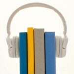 Creative concept of books wearing headphones, symbolizing audiobooks or learning.